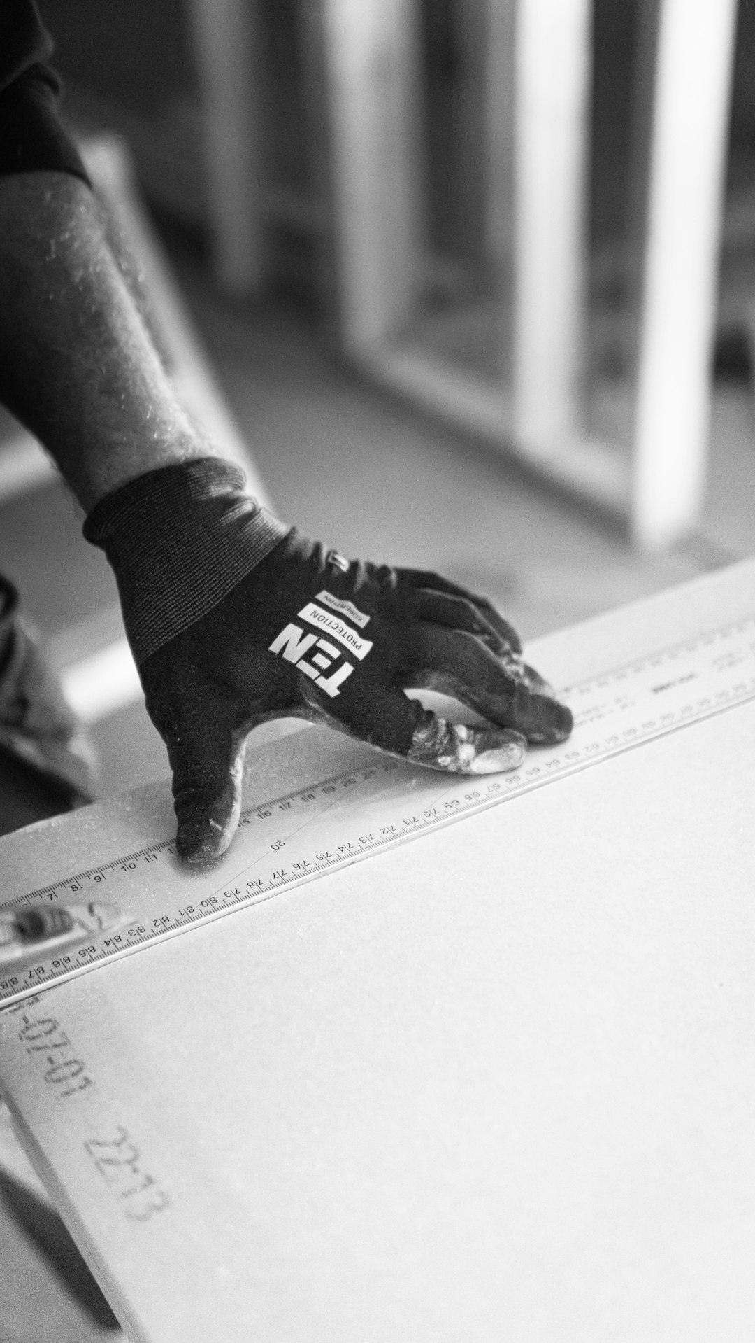 Working with a plaster wall cutting a board while using working gloves from Ten Protection.